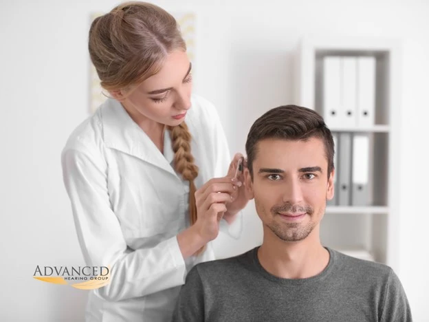 Audiologist administers a hearing test to a client to check for hearing loss.